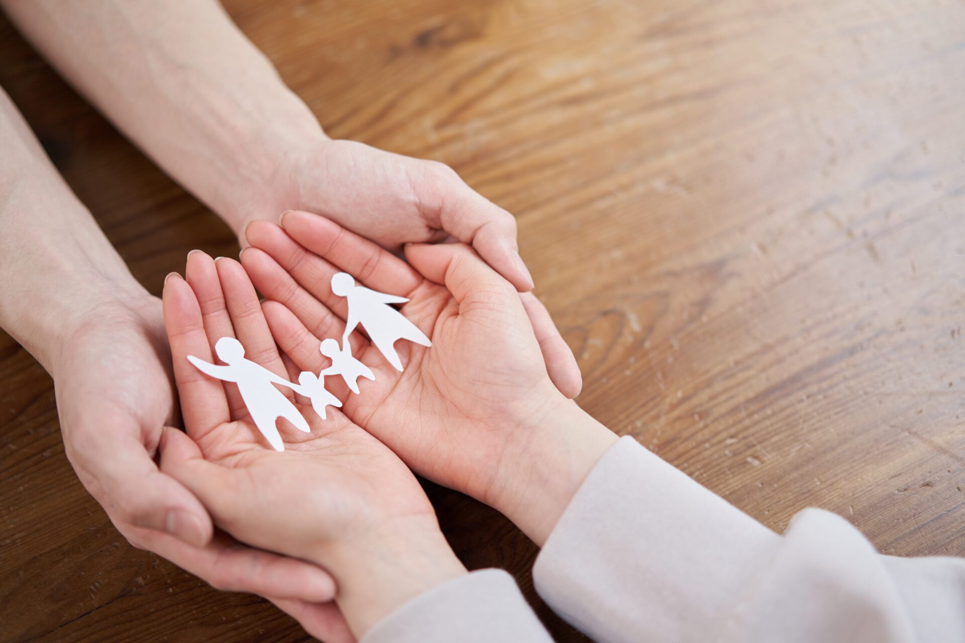 Two people holding a paper family in their hands.